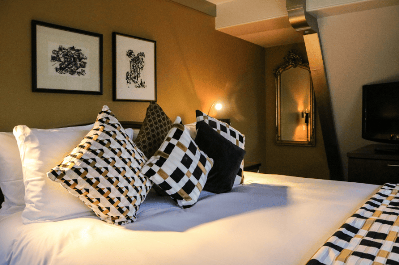 Elegantes Detail des Bettes in der Grand Suite des Ambassade Hotels in Amsterdam, mit luxuriöser Bettwäsche und raffiniertem Design.