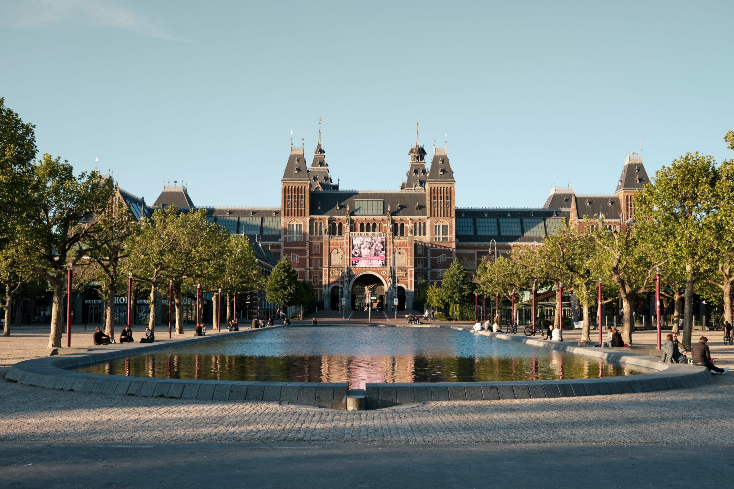 The rijksmuseum building in amsterdam with its grand entrance and gardens.