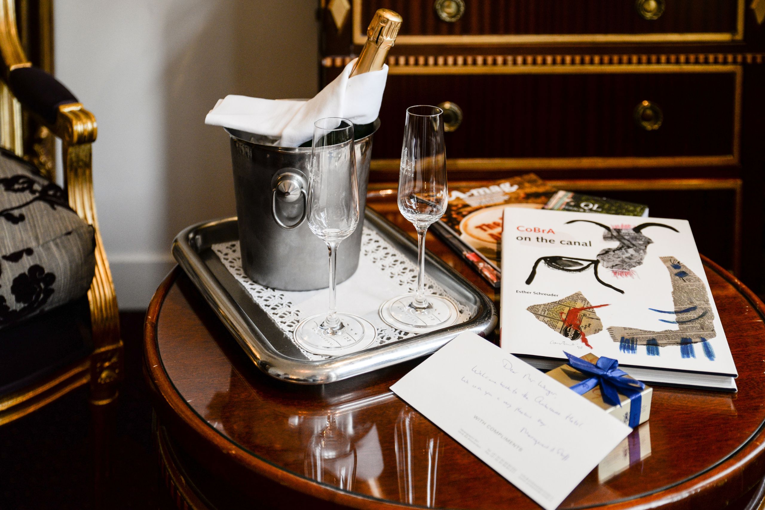 Flasche Champagner mit Willkommenskarte in einem Gästezimmer des Ambassade Hotels.