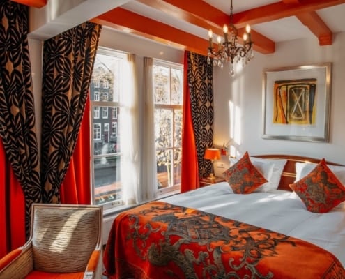 Kamer met oranje tinten en met uitzicht op Herengracht in Ambassade Hotel Amsterdam