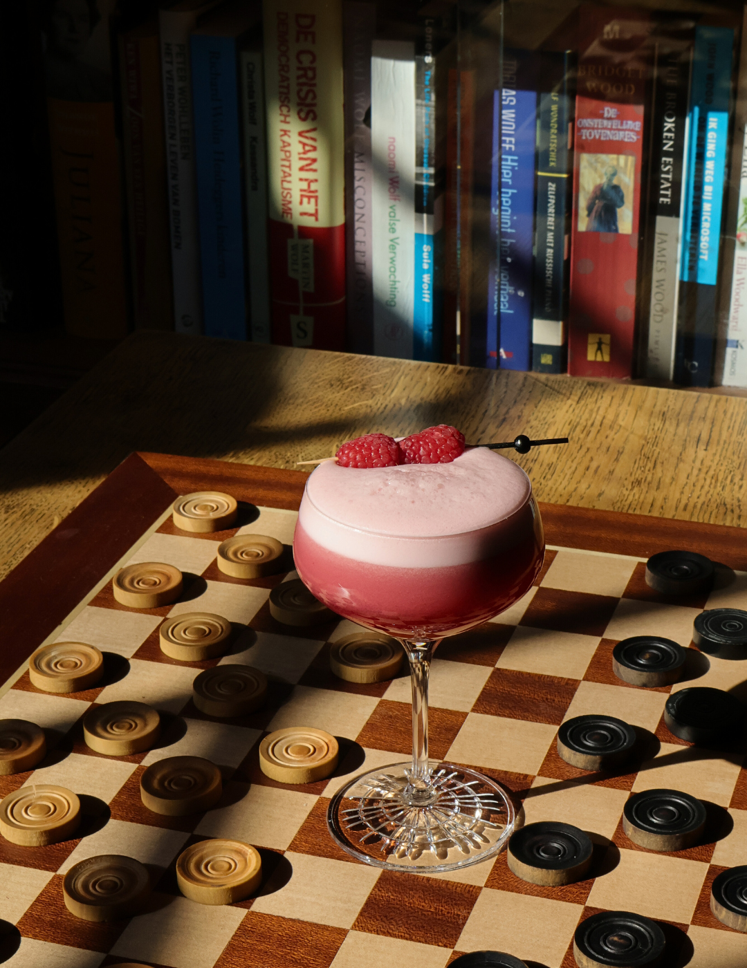 Cocktail créatif servi sur un damier au Library Bar de l’hôtel Ambassade à Amsterdam.