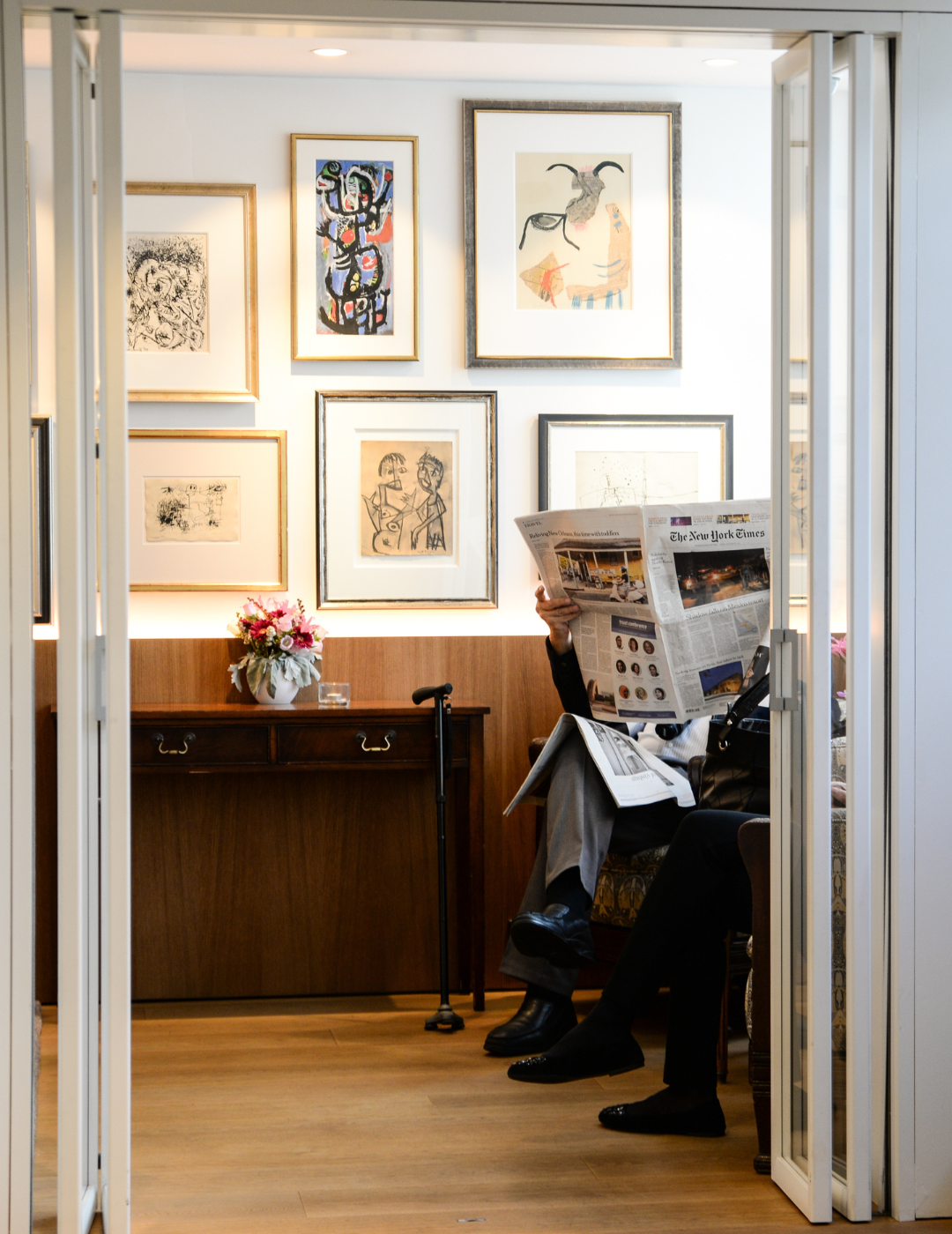 Un invité lit un journal dans le Cobra Lounge de l’hôtel Ambassade, entouré d’art moderne.