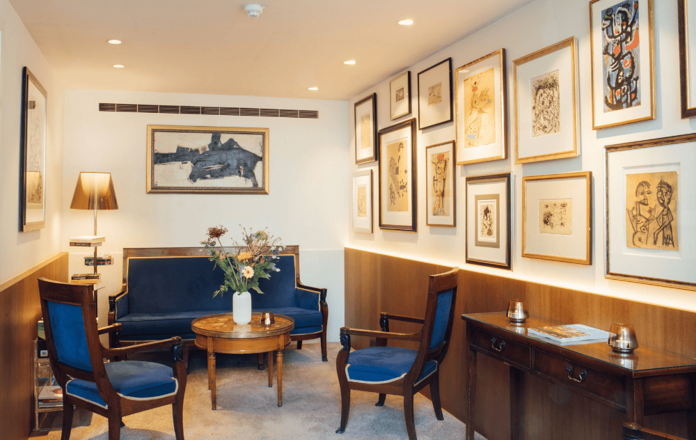 Une partie du Cobra Lounge de l’hôtel Ambassade à Amsterdam, avec des œuvres d’art COBRA colorées et des sièges confortables.