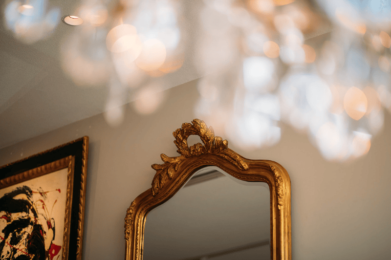 Détail décoratif d'un miroir et d'un lustre à l'hôtel Ambassade à Amsterdam, mettant en valeur un intérieur élégant.