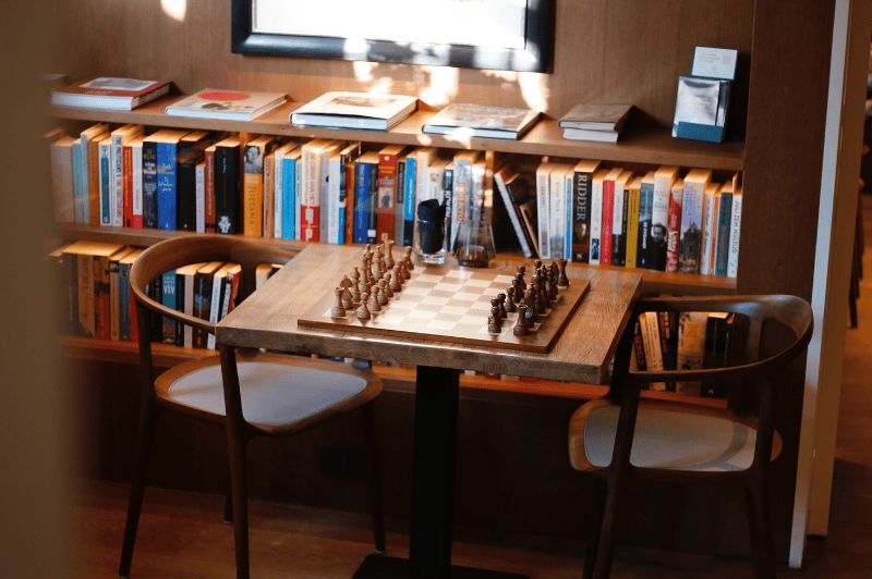 Hall d’hôtel rempli d’art à l’Hôtel Ambassade à Amsterdam, avec mobilier élégant et présentoirs de livres.