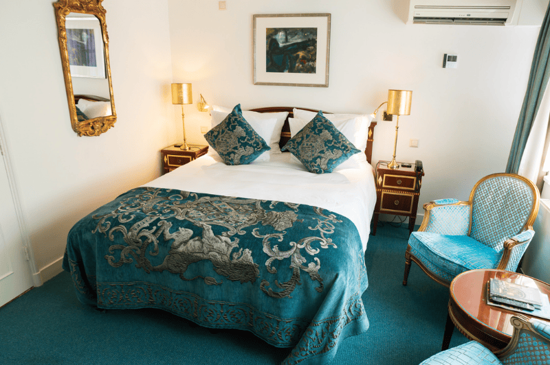 Chambre Classic Deluxe à l’Ambassade Hotel à Amsterdam avec mobilier élégant et vue sur le canal.