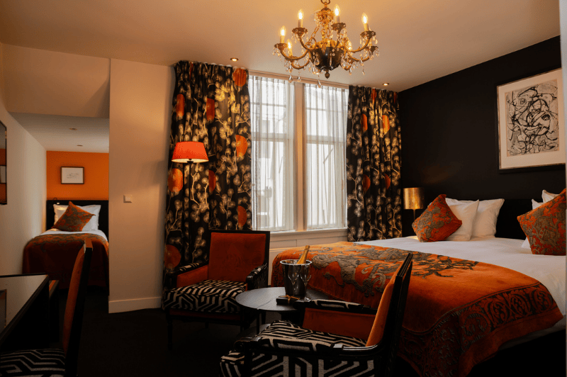 Chambre familiale spacieuse pour quatre personnes à l’Ambassade Hotel à Amsterdam avec des lits confortables et un intérieur élégant.