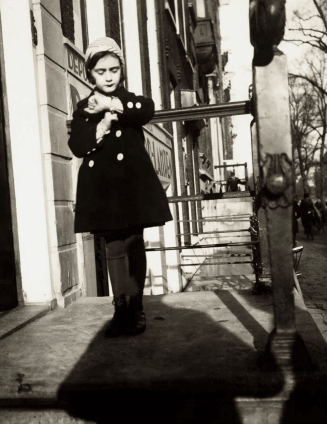 Photo historique d'Anne Frank sur l'escalier d'une maison de canal à Amsterdam.