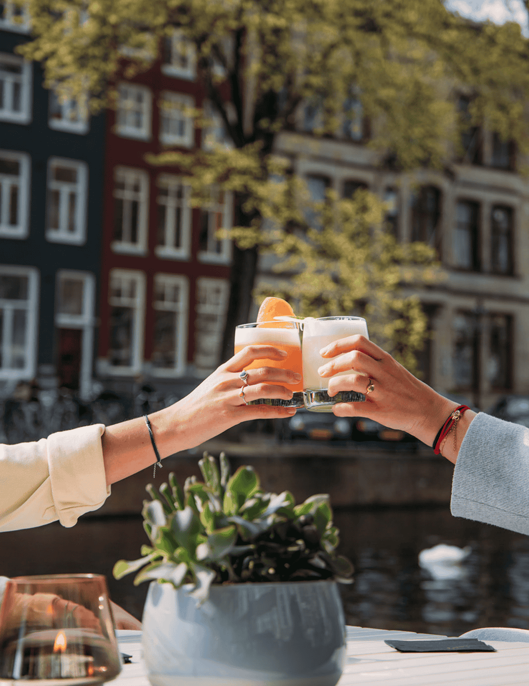 Des invités lèvent leur verre pour un toast sur la terrasse de l’Ambassade Hôtel.