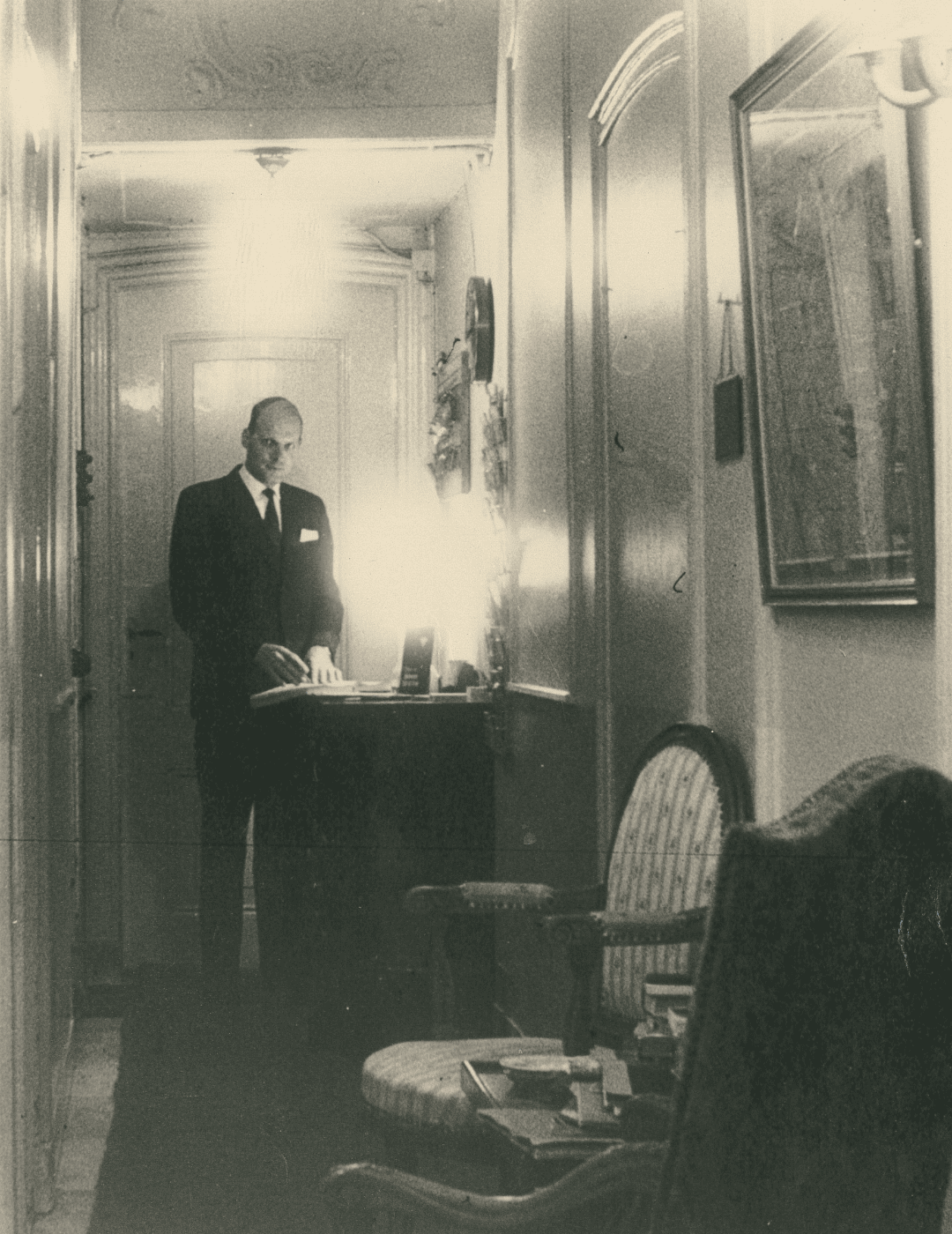 Photo vintage d'un membre du personnel à la réception de l'hôtel Ambassade à Amsterdam.