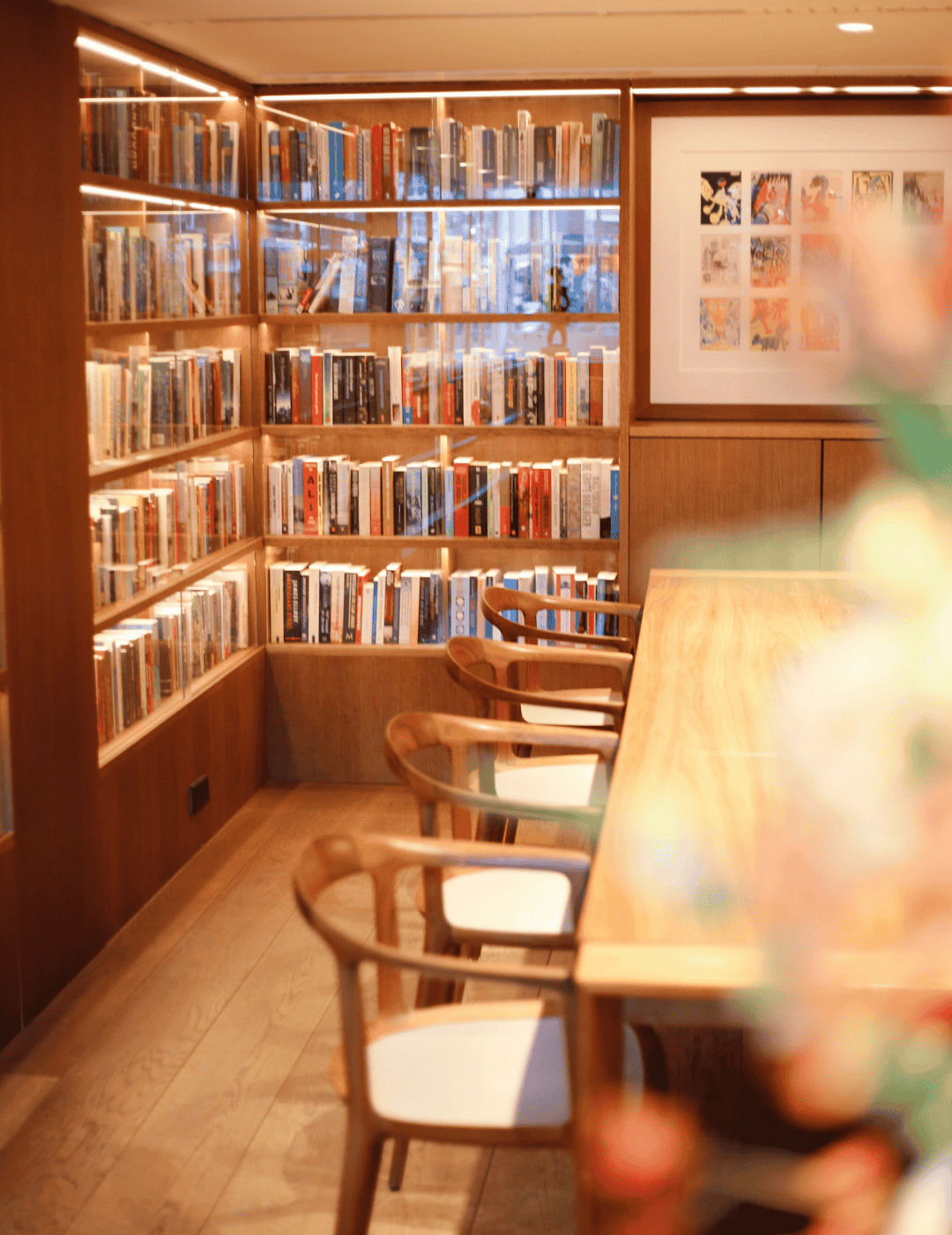 Le Library Lounge de l’Ambassade Hotel avec des livres, des œuvres d’art et des sièges élégants.