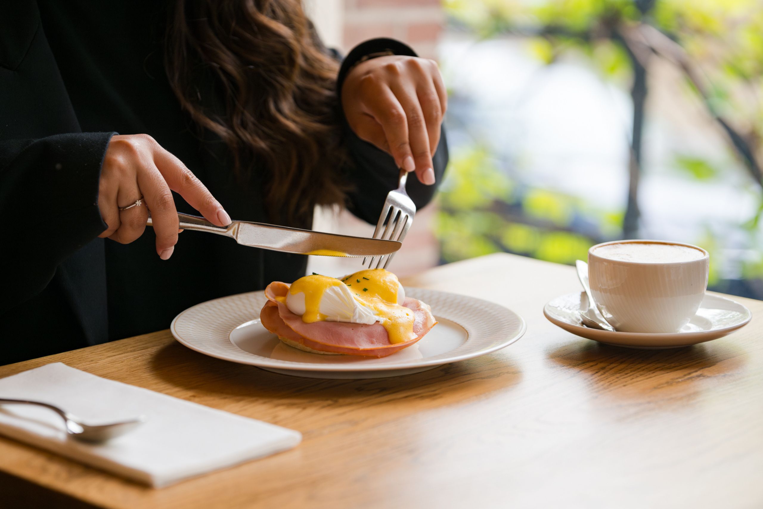 Un client savoure son petit-déjeuner avec vue sur les canaux d’Amsterdam à l’Ambassade Hôtel.