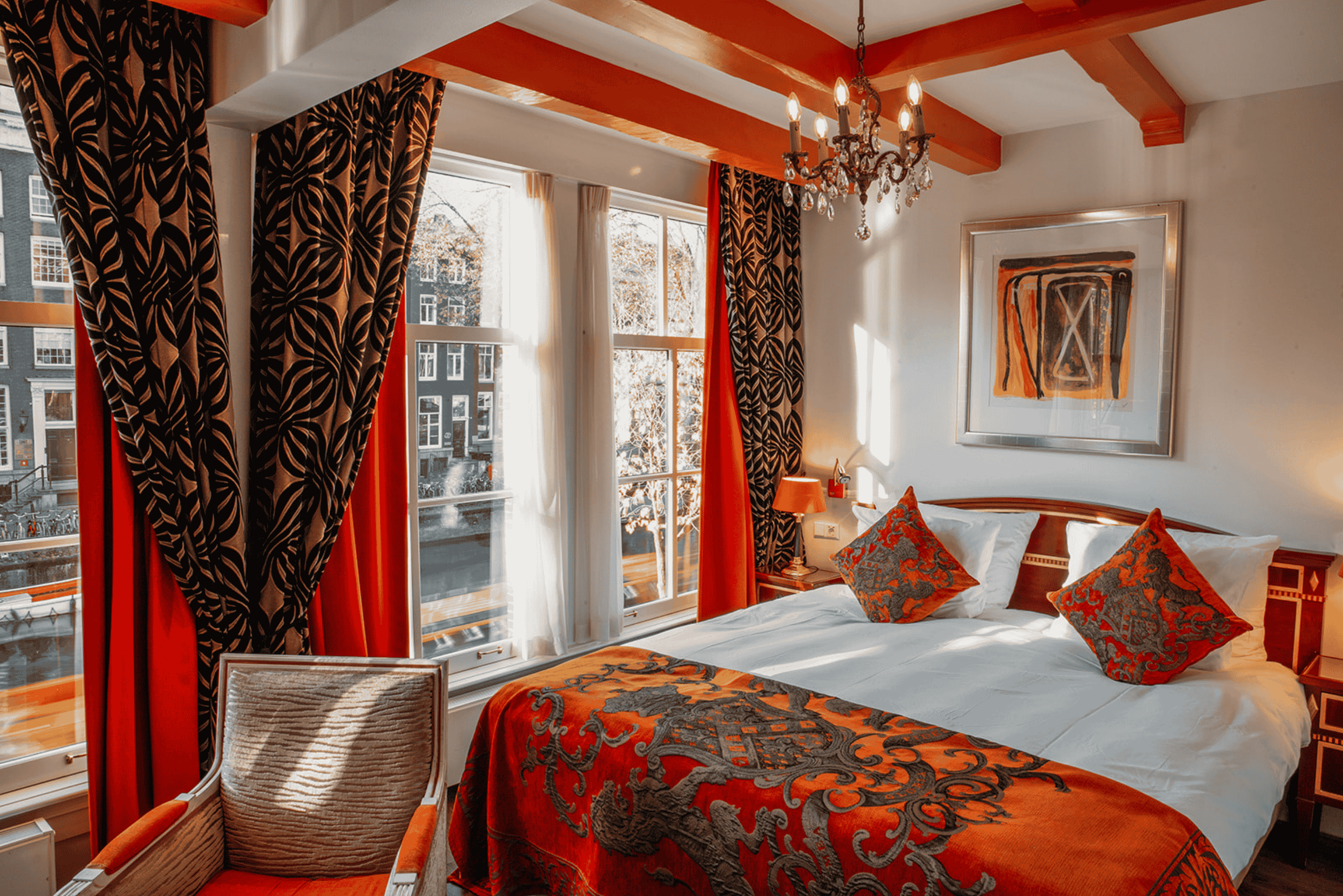 Chambre Superior Deluxe avec vue sur le canal et tons orangés à l’Ambassade Hotel à Amsterdam, surplombant la Herengracht.