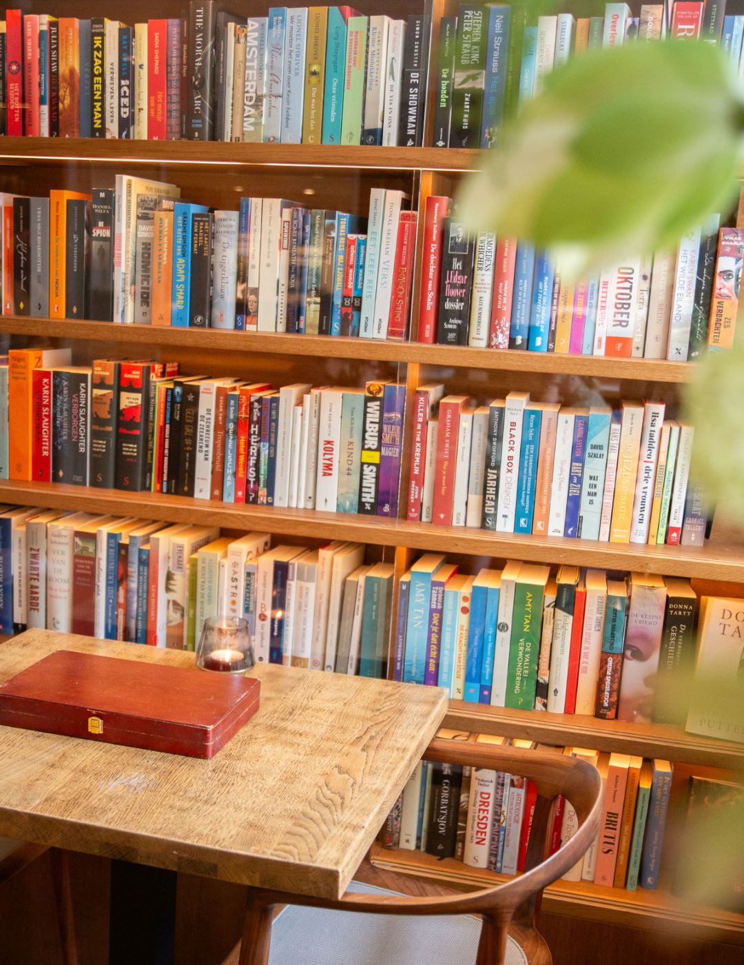 Gros plan sur des livres et une petite table dans le salon bibliothèque chaleureux de l’Ambassade Hôtel à Amsterdam.