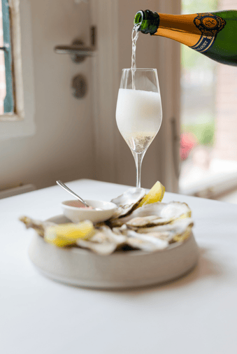 Cava et huîtres fraîches servies à la Brasserie Ambassade à Amsterdam – parfait pour une expérience gastronomique raffinée.