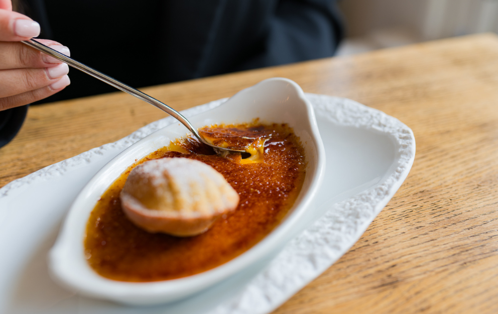 Dessert classique crème brûlée servi à la Brasserie Ambassade à Amsterdam, avec une croûte caramélisée dorée.