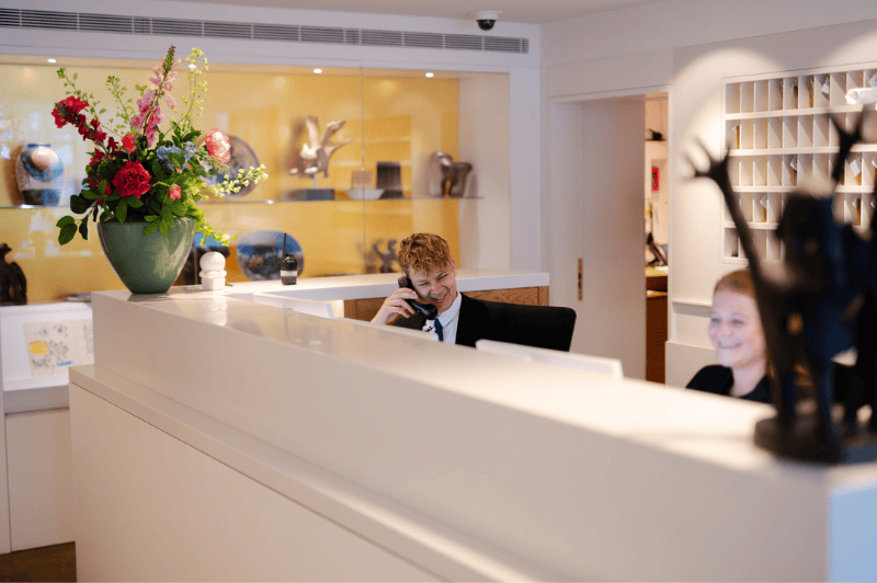 L’équipe de la réception de l’Hôtel Ambassade à Amsterdam est prête à accueillir les clients chaleureusement et à les assister.