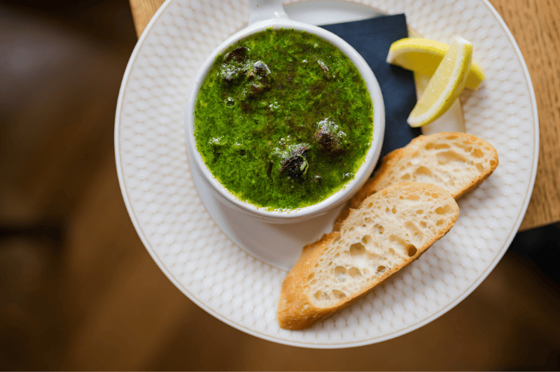 Escargots servis à la Brasserie Ambassade à Amsterdam, préparés avec du beurre à l’ail et aux herbes dans le style classique français.