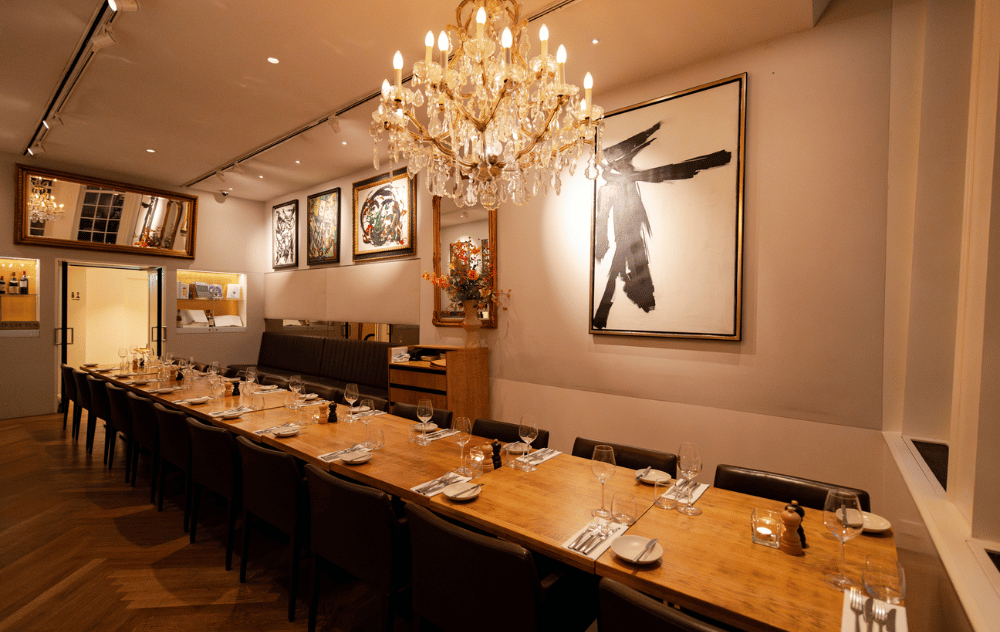 Lounge Wolvecamp à la Brasserie Ambassade à Amsterdam avec une longue table dressée pour un dîner privé élégant.