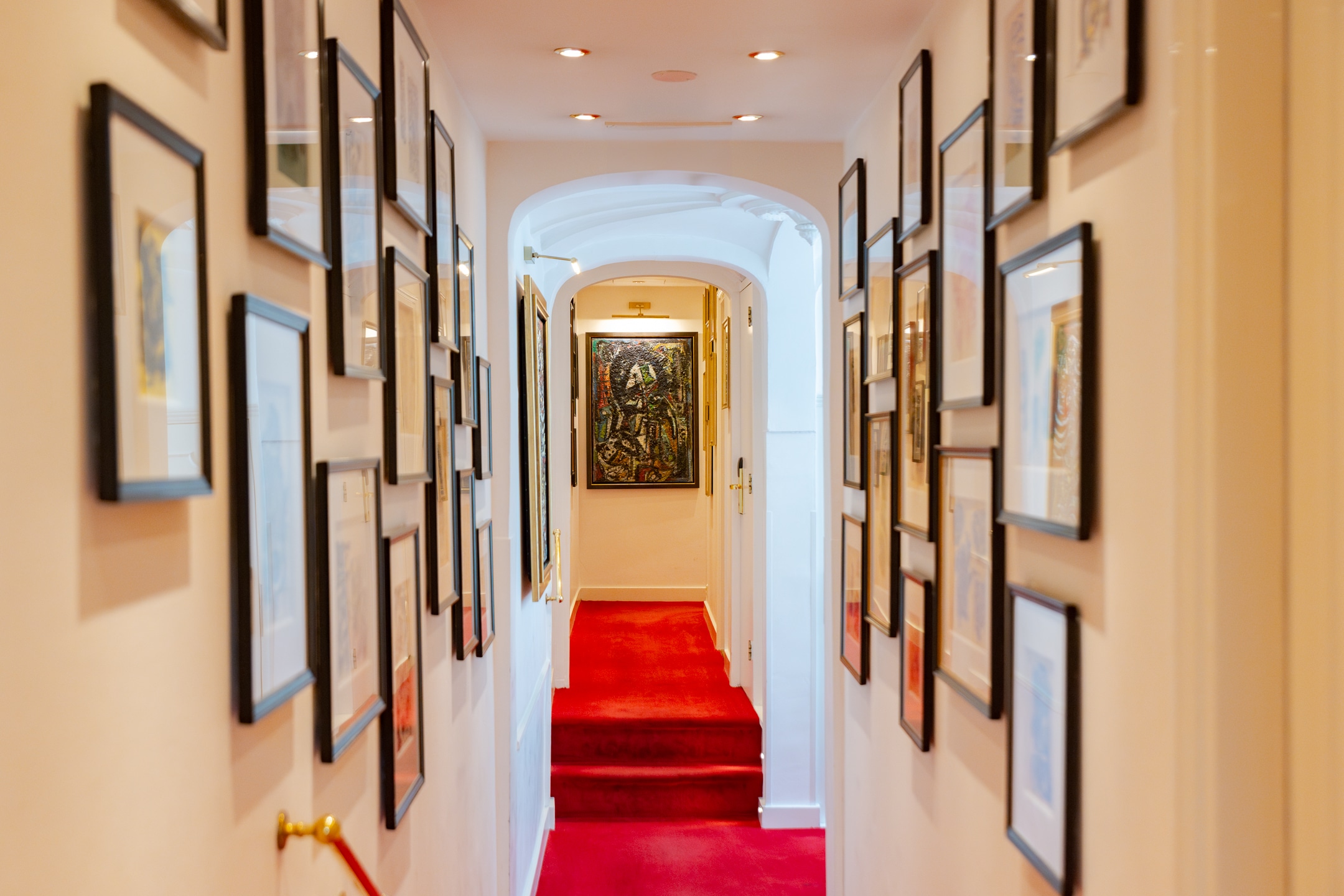 Couloir du premier étage de l'hôtel Ambassade avec des œuvres CoBrA de Wolvecamp sur les murs.