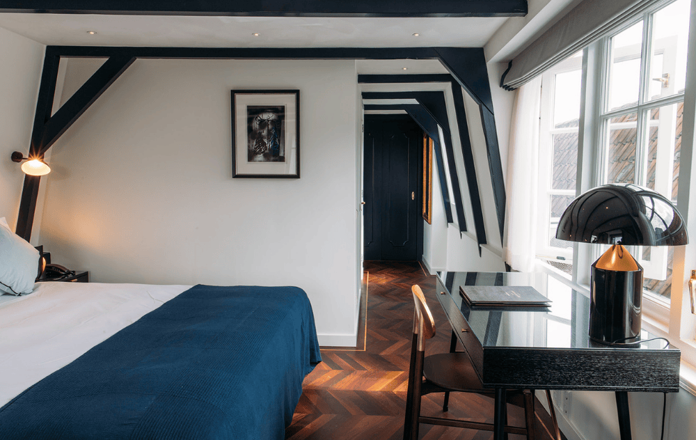 Chambre Classic Deluxe à l’Ambassade Hotel avec un petit bureau.