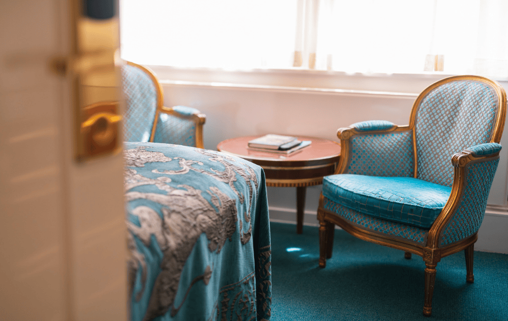 Vue dans la chambre de l’Ambassade Hotel, montrant un coin salon confortable.