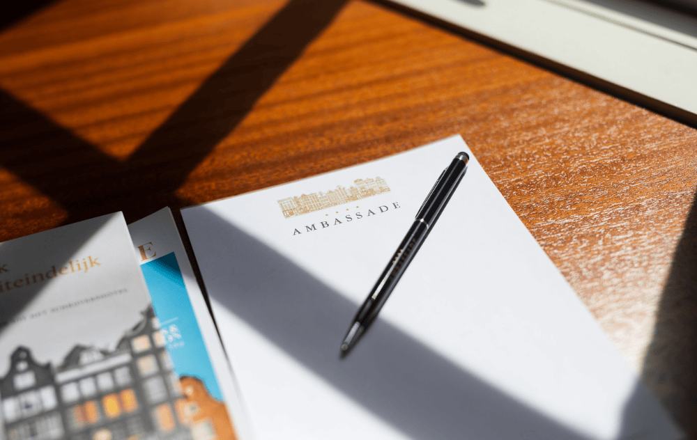 Cahier avec un stylo sur un bureau dans une chambre d’hôtel à l’Ambassade Hotel.