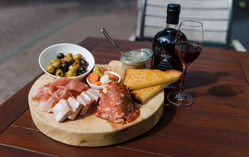 Planche apéritive avec assortiments de snacks sur la terrasse de l’hôtel Ambassade.