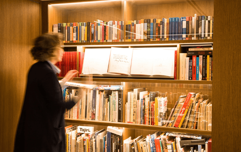 Guest browsing books in the library lounge at the ambassade hotel.