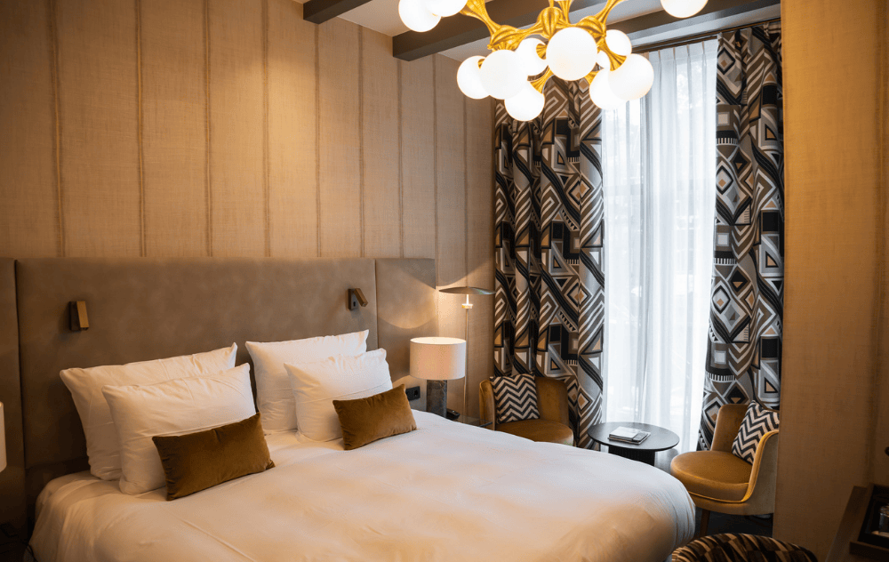 Chambre Deluxe avec vue sur le canal à l’Ambassade Hotel, avec un lit confortable et un coin salon confortable.