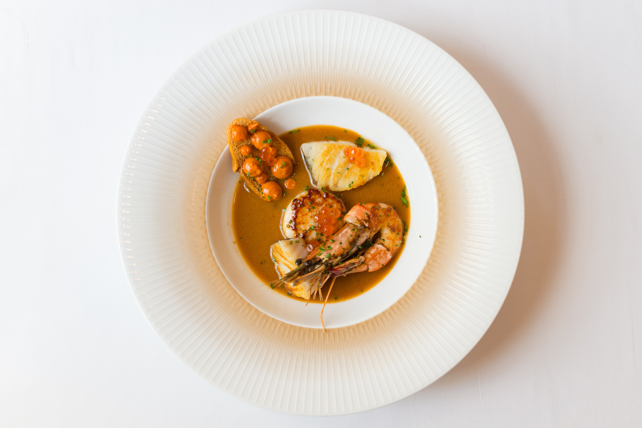 Bouillabaisse served at brasserie ambassade in amsterdam, presented in elegant french style.