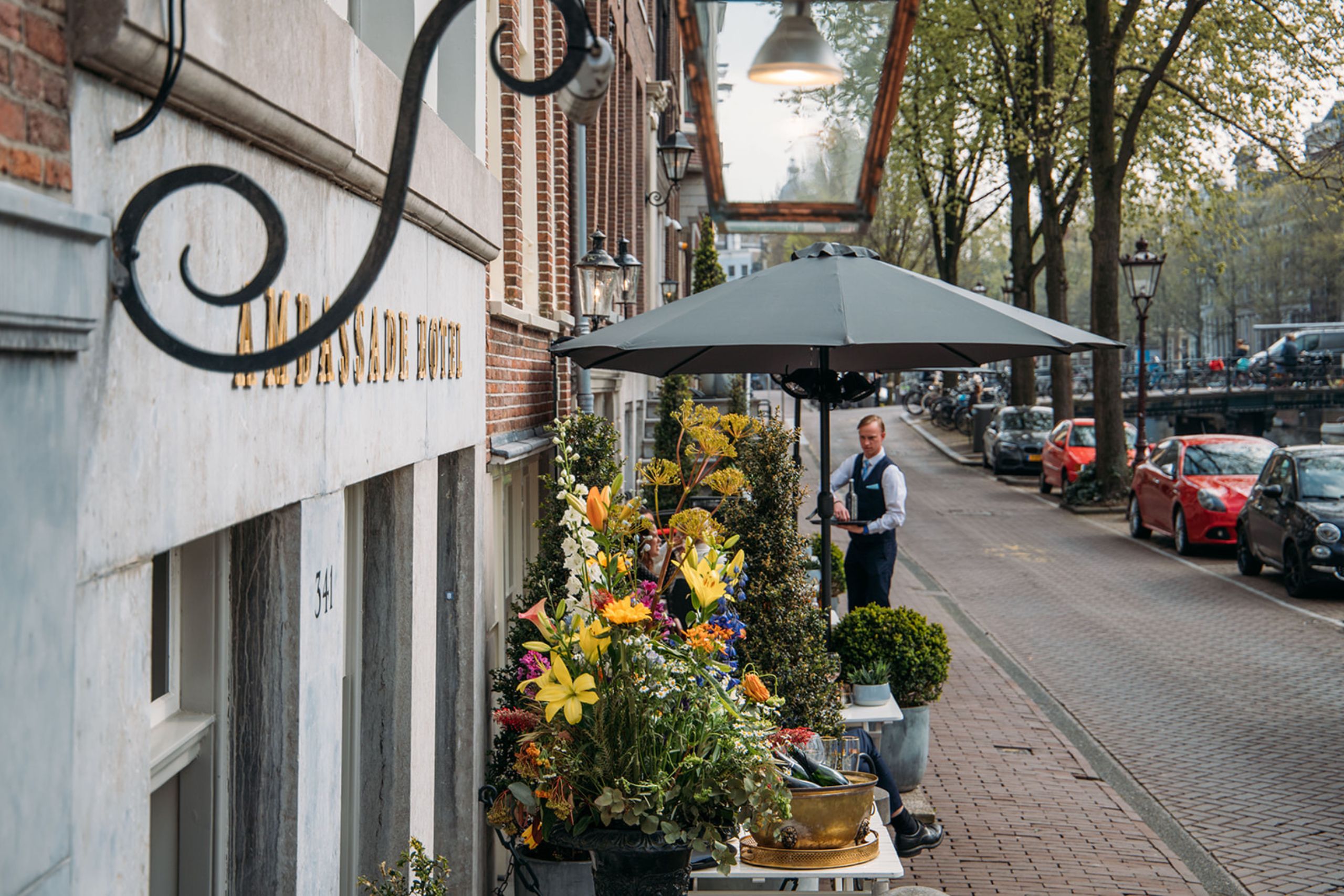 Charming terrace of brasserie ambassade with canal views in amsterdam, perfect for outdoor dining and drinks.