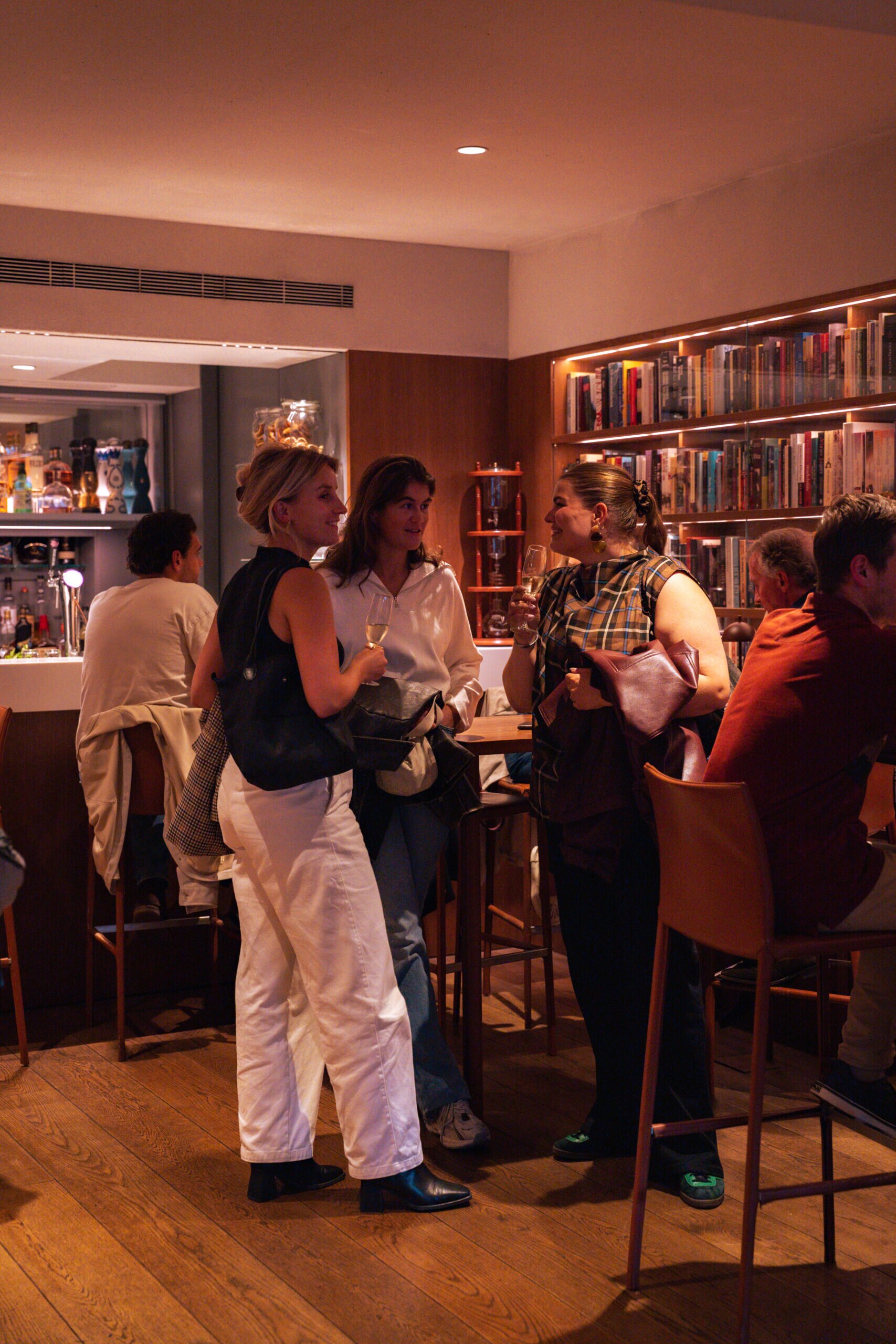 Guests enjoying drinks in the cosy library bar at the ambassade hotel
