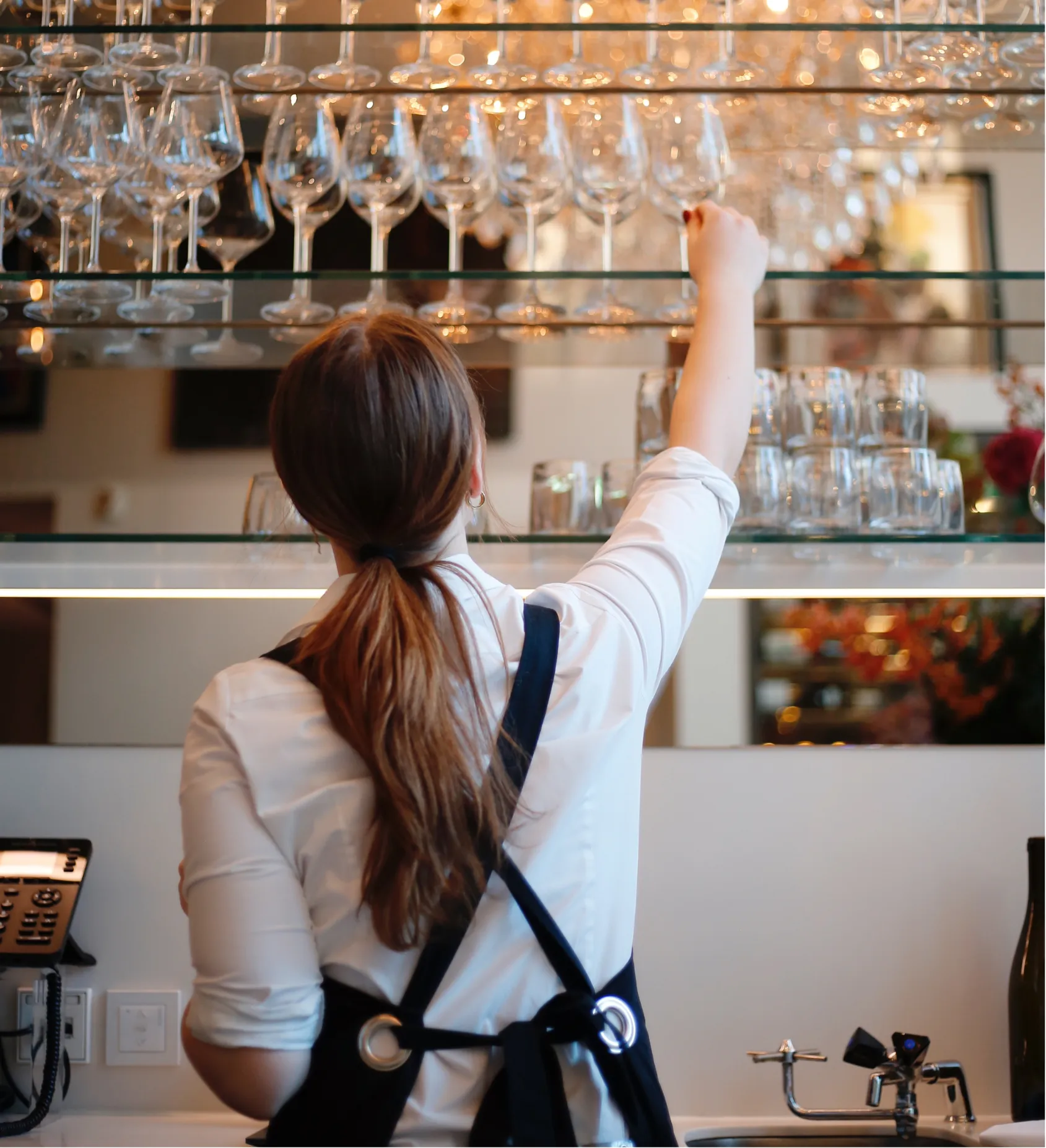 Employé prenant des verres à vin à l'Ambassade Hotel.