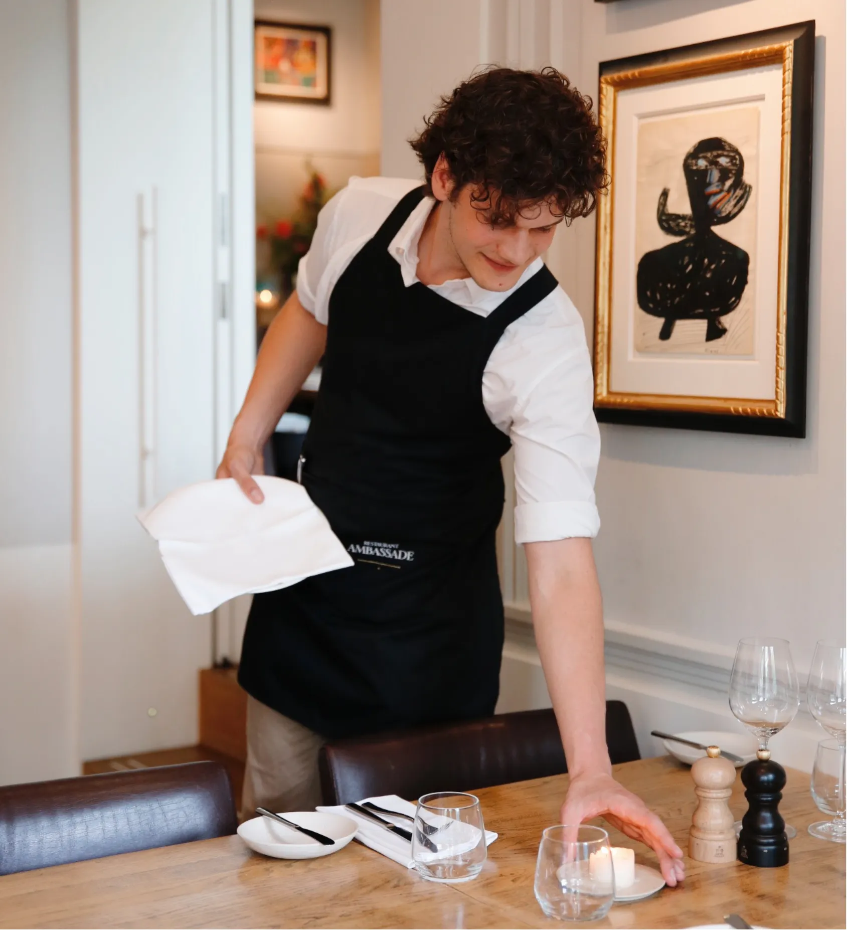 Employé dressant la table dans la brasserie de l'Ambassade Hotel.